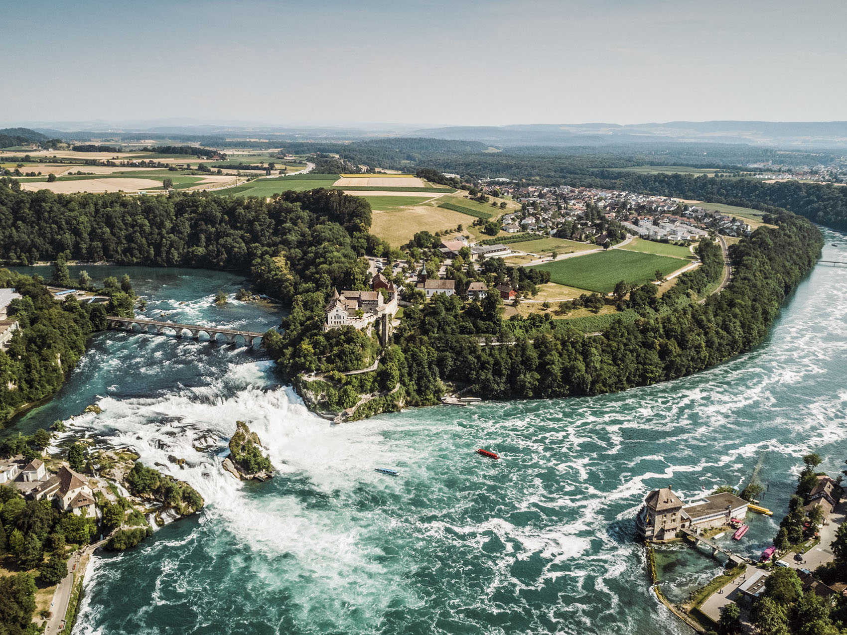 Vista aérea de del río Rin y sus cataratas visitadas por un barco fluvial de crucero